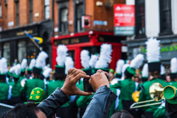 Person taking photos of the march, the Saint Patrick's day parade in Dublin 2022