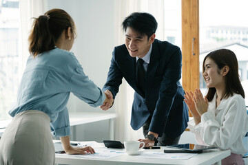 Asian businessman and woman shake hands as hello in office. Friend welcome, introduction, greet or thanks gesture.