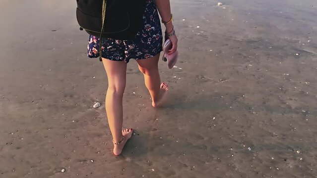 Woman enjoying on a black sanded ocean beach.	
