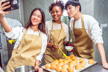 Students In Cookery Class Mixing Ingredients For Recipe In Kitchen.Group of young people taking...