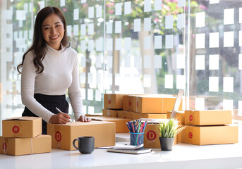 Shipping shopping online, startup small business owner writing address on cardboard box at...