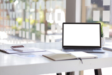 Laptop blank white screen on desk in financial office.