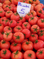Pink tomatoes on a farmers market stall in Yalikavak, Bodrum, Turkey. On the price tag is written pink (pembe)  in Turkish.      