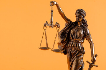 Figure of justice holding scales over orange