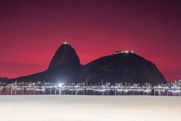 sky with the color red, under the influence of the ashes of the volcano of tonga in the cove of Botafogo in Rio de Janeiro.