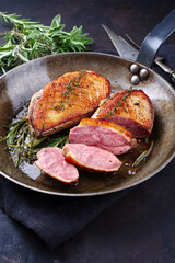 Traditionell gegrilltes Gourmet Entenbrust Filet mit Haut serviert mit Kräutern als close-up in...