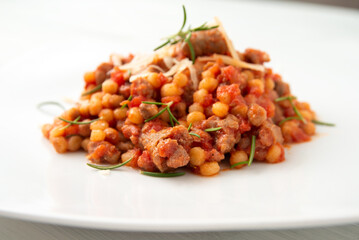 Fregula con sugo di salsiccia di maiale, tipica pasta di semola della cucina Sarda, cibo Italiano 