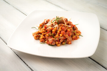 Fregula con sugo di salsiccia di maiale, tipica pasta di semola della cucina Sarda, cibo Italiano 