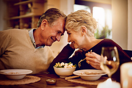 Love makes everything taste better. Shot of an elderly couple enjoying a meal and wine together at home.