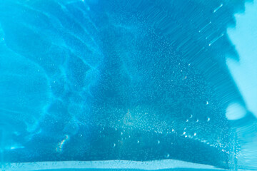 
Blurred texture of water ripples on a blue background. Shadow of water in sunlight. Mockup for product, spa or travel background. Marble water surface as wallpaper background