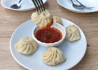 Pork momo, served pan fried eat with chilli paste sauce, Bhutan food.