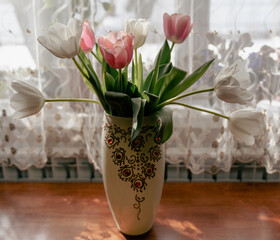 Bouquet of tulips in a flowerpot on the table in the room
