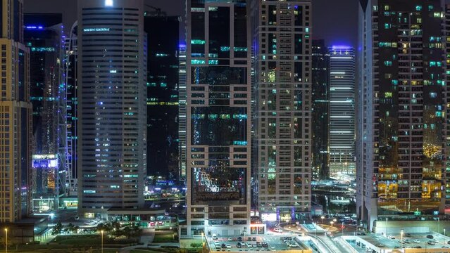 Aerial view of Jumeirah lakes towers skyscrapers during all night timelapse with traffic on sheikh zayed road.