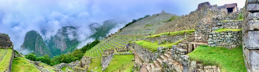 grass in a field the ruins of the ancient city of machu picchu with foggy	