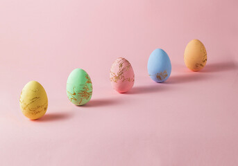 Cute colorful easter eggs on the pink pastel background.