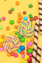 Fototapeta na wymiar Colorful different kinds of candies isolated on yellow background