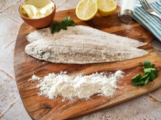 raw fish with flour on a wooden board