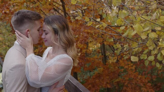 Close up of newlyweds. Lovely young caucasian bride and groom huggin and kiss lovingly. Happy wedding couple.
