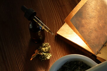 Essential oil made from medicinal cannabis. Buds. Skunk. Marijuana on wooden backgroun. Bottle and mortar.