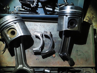 burnt broken piston of car engine on workshop table