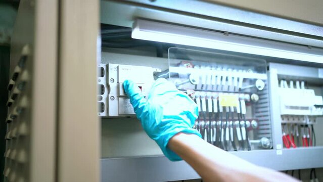 Engineer close circuit breakers in the steel electric control panel. It is in the off position. Power electric in electrical cabinet control. Electronic and industrial concept.