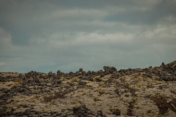 Obraz premium Famous Lava rock formations close to Snæfellsnesvegur, Iceland on a cloudy summer day. Magnificent lava fields opposed to grey skies.