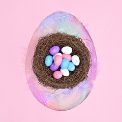 Egg shape with neast with eggs on pastel pink background. Flat lay creative Easter concept