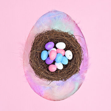 Egg shape with neast with eggs on pastel pink background. Flat lay creative Easter concept