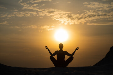 Yoga silhouette. Meditation girl on the background of sea during sunset. Fitness and healthy lifestyle.