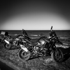 Fototapeta na wymiar 2 off road motorcycles standing side by side by the sea
