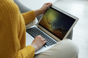 Fototapeta premium Woman working with laptop indoors, closeup. Forex trading