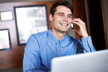 Happy clients and smiles all around. Shot of a young businessman talking on the phone while sitting...