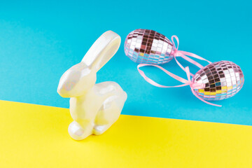 Happy Easter in Ukraine. Easter mirror eggs and holographic bunny on a blue-yellow background. Creative concept of Ukrainian Easter