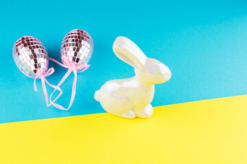 Happy Easter in Ukraine. Easter mirror eggs and holographic bunny on a blue-yellow background. Creative concept of Ukrainian Easter