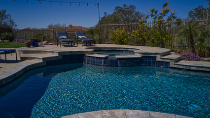 Travertine deck with pool, spa and outdoor kitchen.