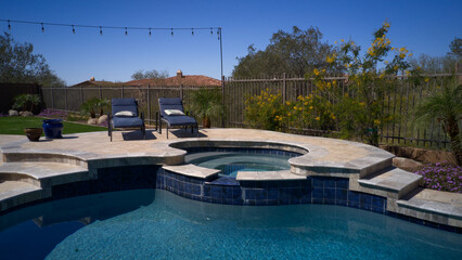 Travertine deck with pool, spa and outdoor kitchen.