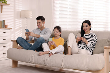 Internet addiction. Family with gadgets on sofa in living room
