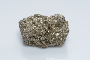 Raw crystalline pyrite (iron pyrite, fool's gold). Mineral pyrite from the group of sulfides. The mineral pyrite on a white background