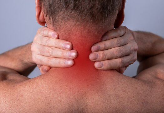 Neck pain or injury. Man hands holding neck with red point closeup. Health problems caused by incorrect posture, pinched nerve, muscle spasm concept. High quality photo
