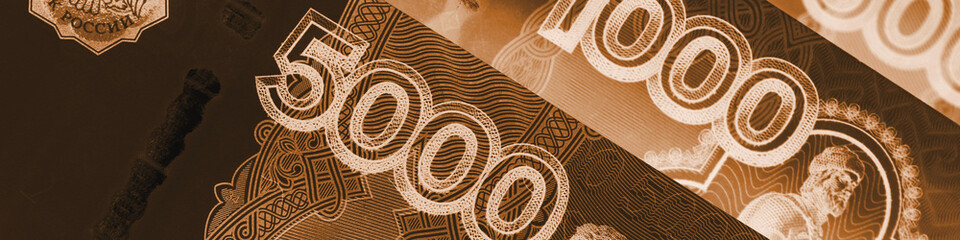 Russian banknotes 5000, 1000 and 500 rubles. Numerals of denomination of bills close up. Dark banner about economy money and finance in Russia. Brown tinted headline. Macro