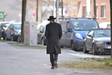 A rabbi walks along a street in Berlin-Wilmersdorf on a cold spring day. 