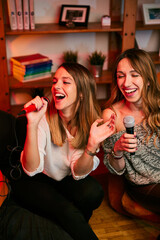 Girls having fun at karaoke night at home.
