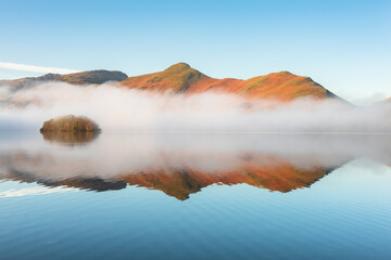 Calming reflections on a sunny morning at Derwentwater in the Lake District, UK.