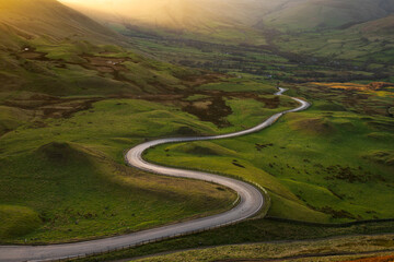 Long winding road in British rural countryside leading off into distance. Peak District, UK. - 493512662