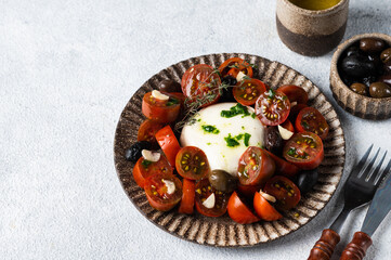 Italian caprese salad with sliced tomatoes, mozzarella, garlic, olive oil on a light background. Top view. Italian food. Healthy food, burrata salad.