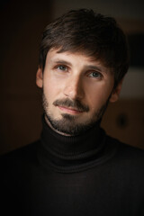 Fototapeta premium Expressive close-up portrait of a man with a beard. natural light. dark background
