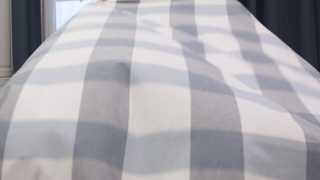 Woman spreading a white gray tablecloth on dining table in the kitchen at home. High quality 4k footage