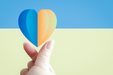 Heart with print the national flag of ukraine in hands, Copy space. stop the war and peace in...