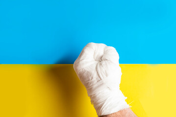 Male hand in the bandage on the Ukrainian flag background