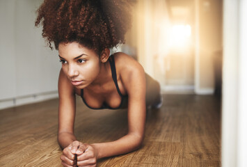 I only compete with myself. Shot of a young woman working out at home.